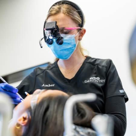 Dental team member using Florida probe to clean between teeth