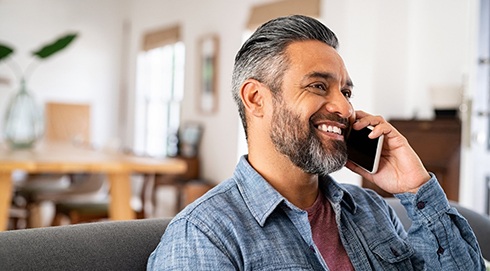 Man in blue shirt smiling on phone