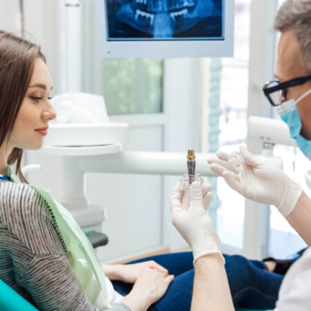Dentist showing dentistry patient dental implant model