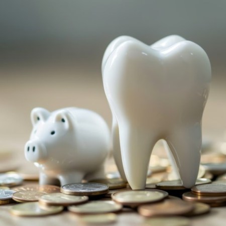 a tooth next to a small white piggy bank