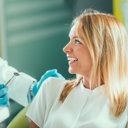 a patient smiling while visiting her cosmetic dentist