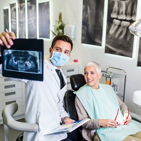 Dental patient reviewing X-ray with dentist