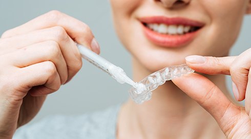 Woman inserting whitening gel into clear applicator tray