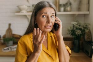 a worried woman on the phone with her emergency dentist