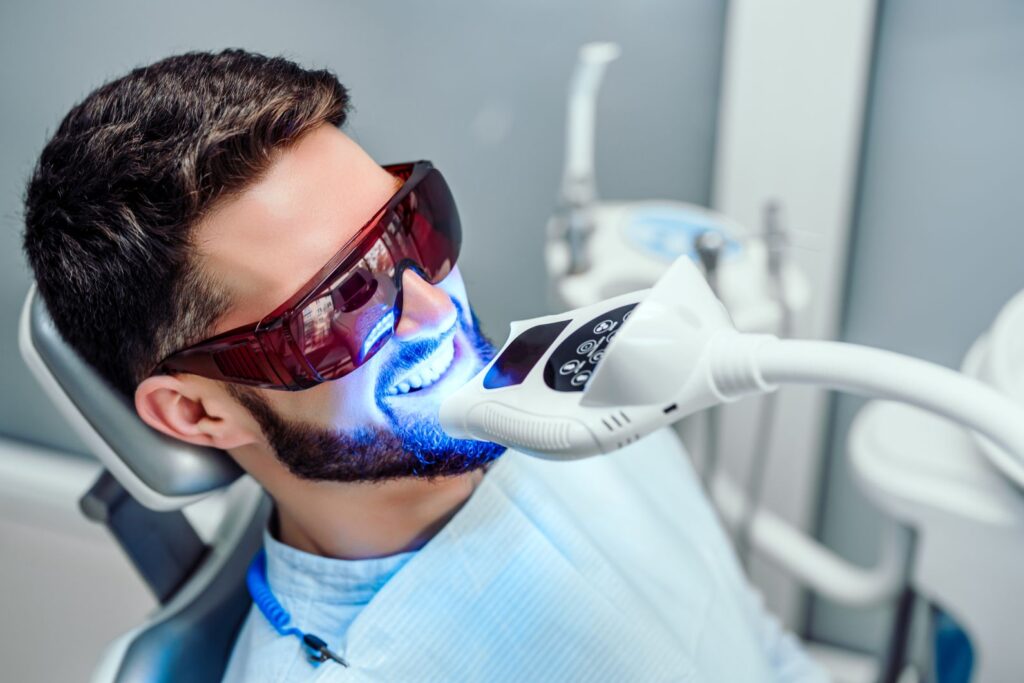 A man in a dentist’s chair getting a professional teeth whitening treatment